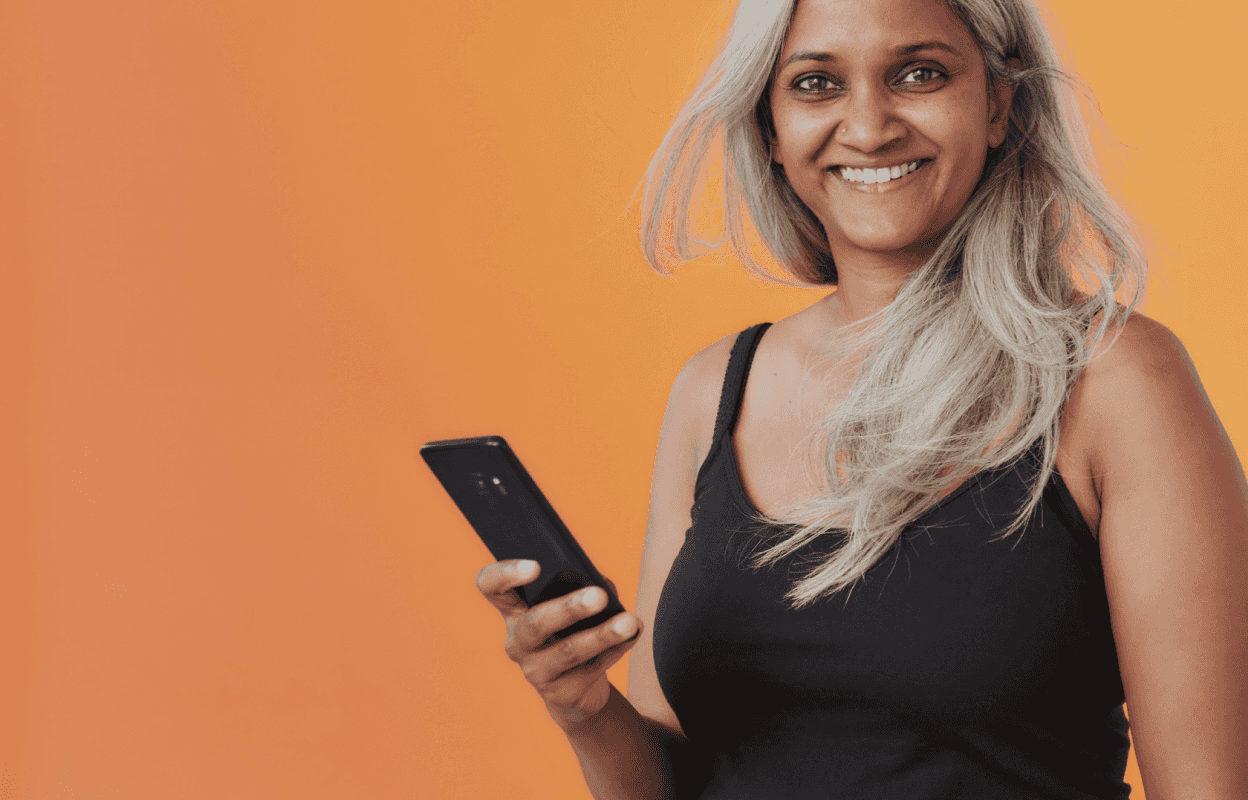 An image with an orange background and a woman holding a phone